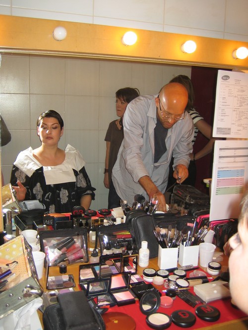 salle de maquillage avec professionnel qui maquille la star devant un miroir