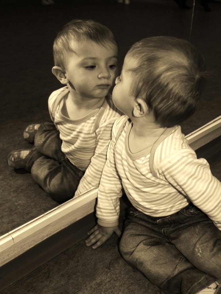 enfant qui se regarde dans une glace