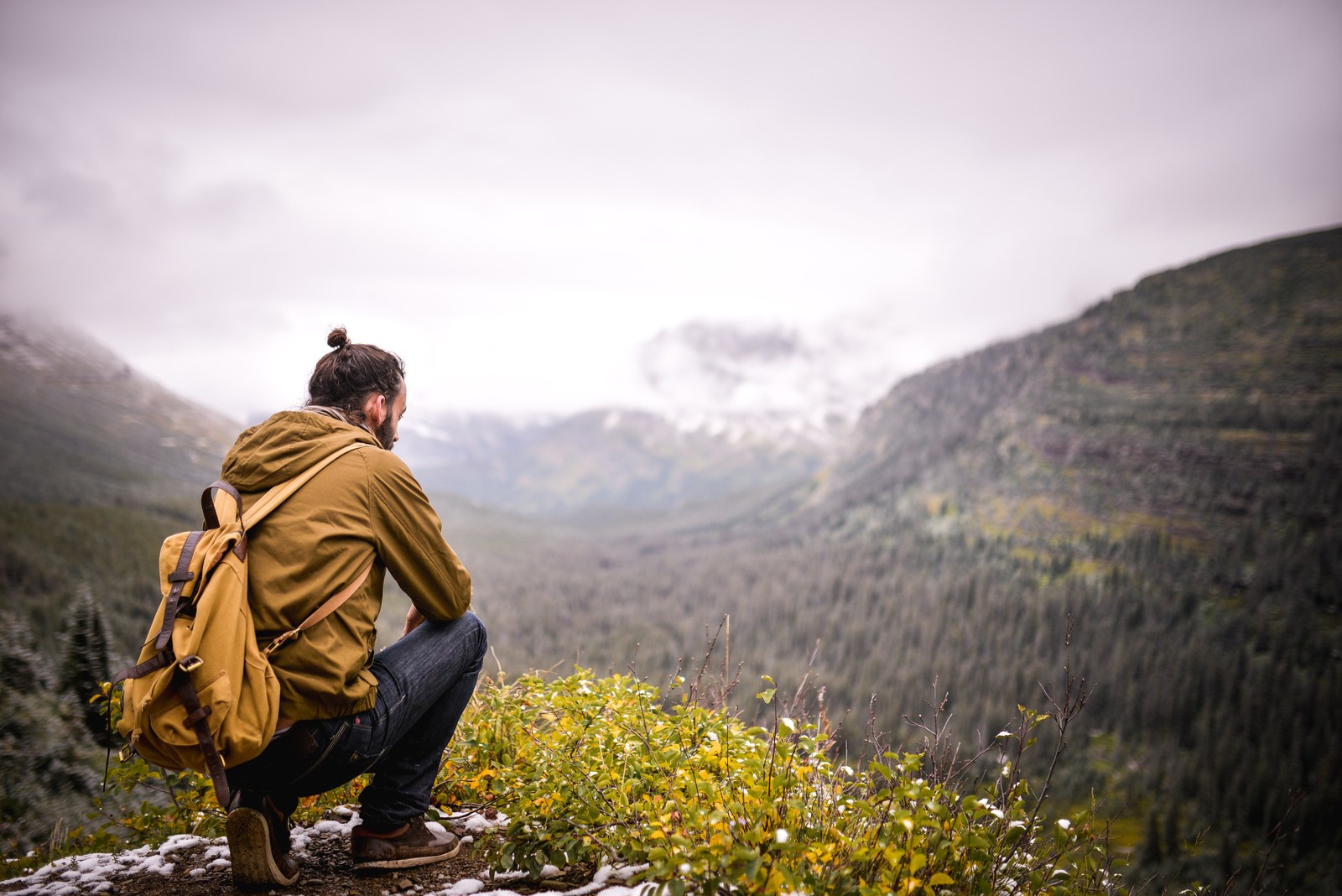 homme seul accroupi en train de regarder le paysage d