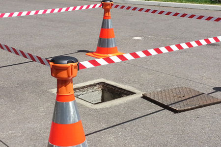 plots qui délimitent une trappe ouverte qui donne sur les égouts