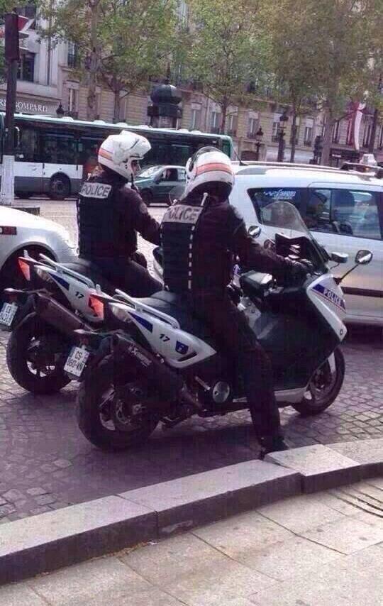 policier avec casque sur leur moto de travail sur une route parisienne