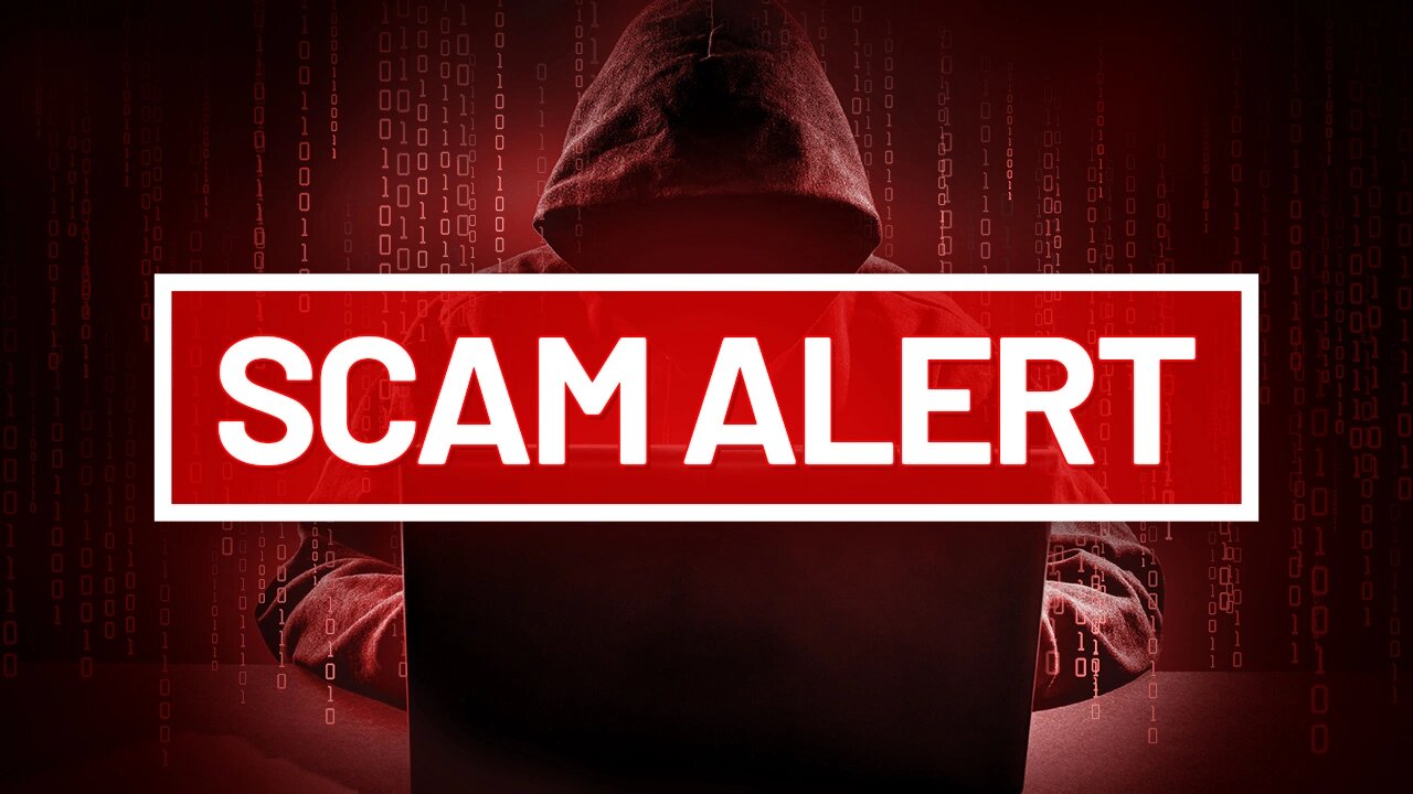 Un haker sur un ordinateur avec une alerte : SCAM ALERT - Définition MegaDico