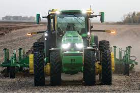 tracteur vert labourant un champs