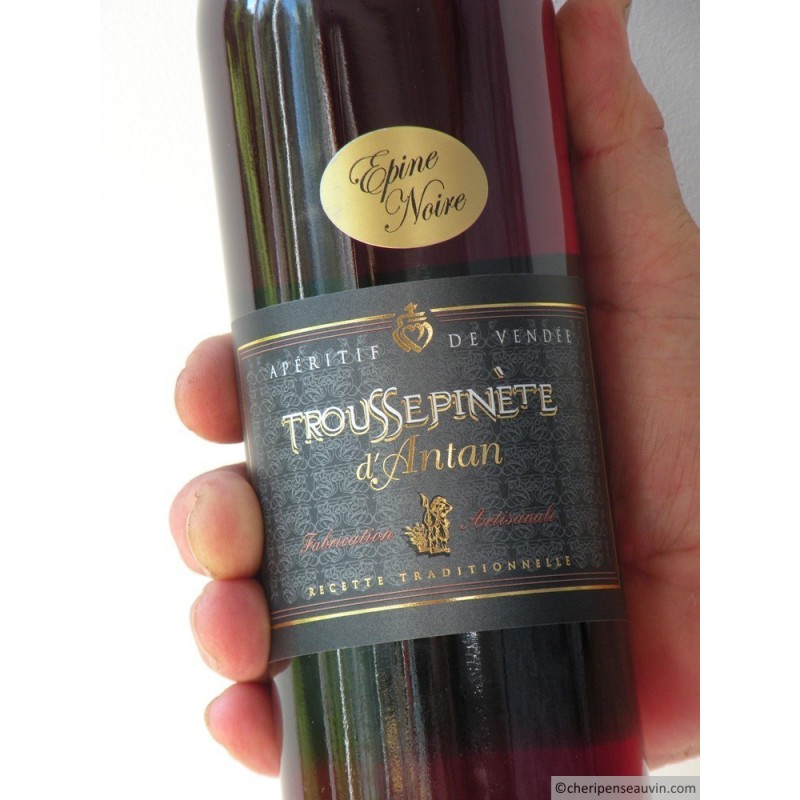 bouteille de troussepinette dans une main